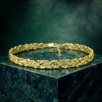 Gold plated brass choker on a dark green marble surface with a dark green background
