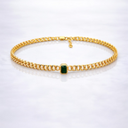 Gold  plated brass necklace with a green gemstone on a grey background