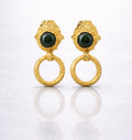 Pair of gold plated brass earrings with green gemstones on a grey background