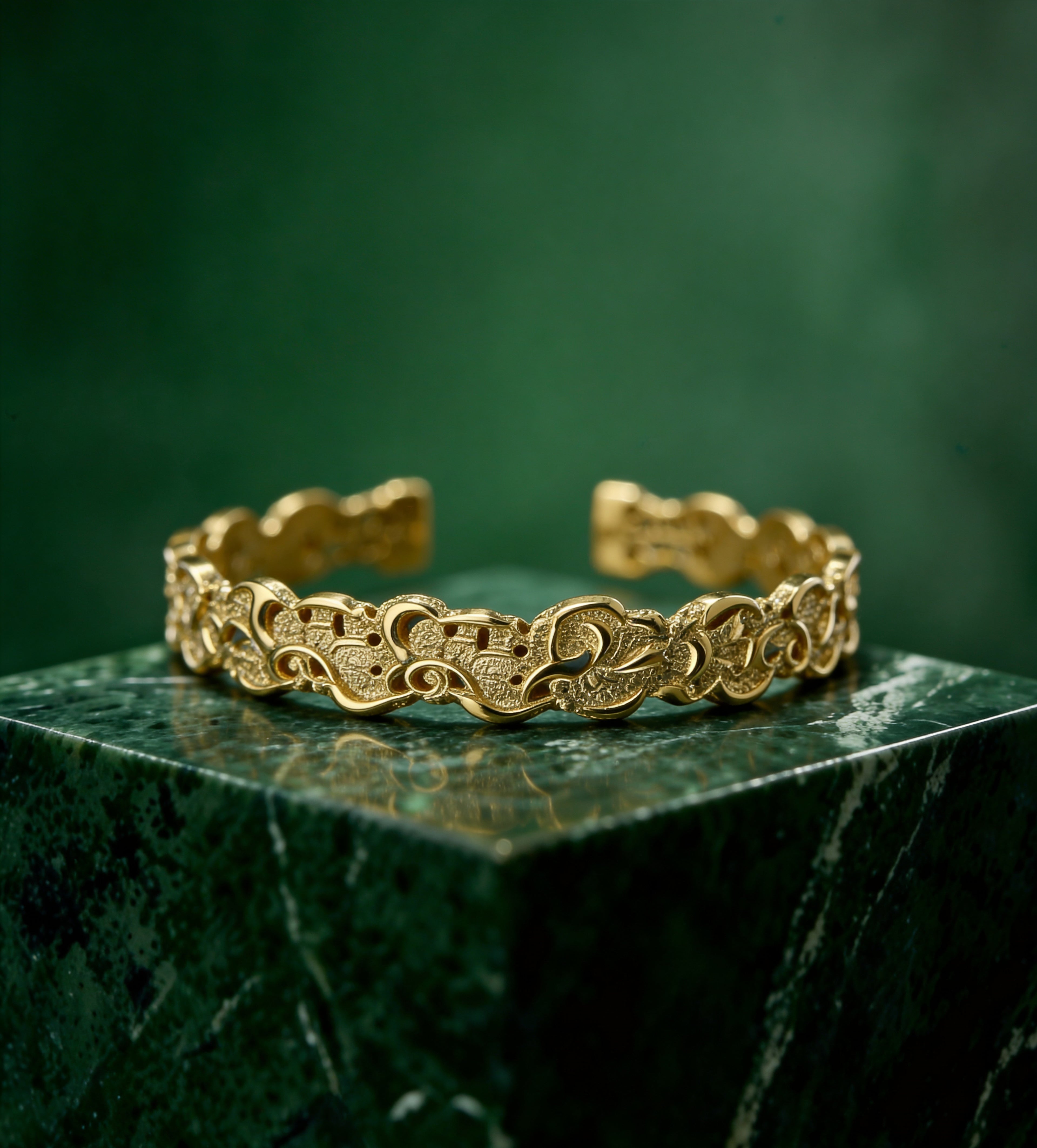 Gold plated brass bracelet with a pattern on a dark green marble 