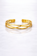 Gold plated brass bracelet on a grey marble surface 